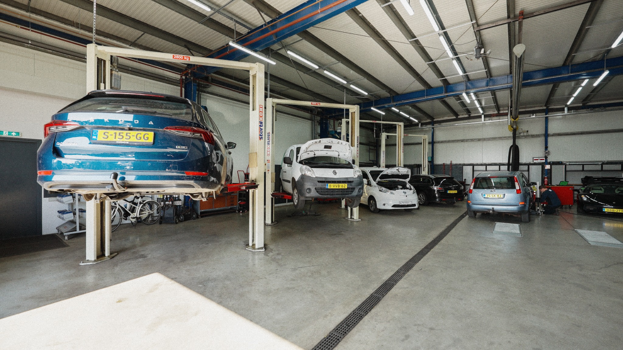 Werkplaats van Vermaat Automotive met auto’s op de hefbrug